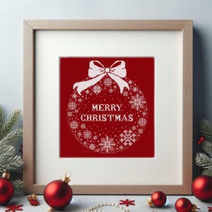 Puede incluir: Diseño de punto de cruz blanco de un adorno navideño con un lazo y el texto "Feliz Navidad" sobre un fondo rojo. El diseño está enmarcado en un marco de madera claro.