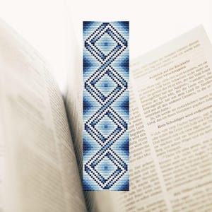 May include: A blue and white beaded bookmark with a geometric pattern. The bookmark is made of small beads that are woven together to create a repeating diamond shape.
