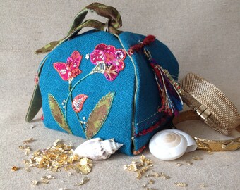 Treasure box in turquoise blue linen and embroidered with flowers in bright colors in a boho spirit.