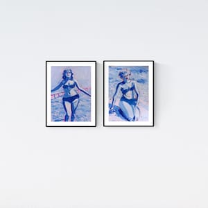 Könnte beinhalten: Zwei gerahmte Kunstdrucke mit blau-weißen Gemälden einer Figur im Bikini. Der linke Druck zeigt eine stehende Figur, der rechte eine sitzende Figur. Beide Kunstwerke verwenden eine monochrome blaue Farbpalette auf weißem Grund.