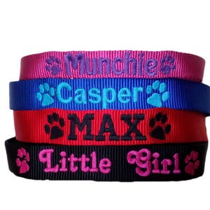 May include: Four colourful dog collars with embroidered paw prints and names: "Munchie", "Casper", "MAX", and "Little Girl".