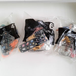 May include: Three plastic bags containing Lilo & Stitch character toys. The bags are labelled with the character's name and number. The characters are Pleakley, Jumba, and David.