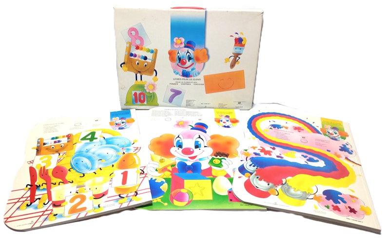 May include: A white rectangular box featuring a colourful clown illustration and the text "LIVRES POUR LE CLOWN" alongside three large activity sheets. The sheets display vibrant graphics of clowns, numbers, paintbrushes, and rainbow patterns.