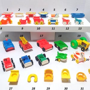 Puede incluir: Una colección de juguetes vintage Fisher-Price Little People, que incluye coches, camiones, mesas y sillas. Los juguetes son de varios colores, como rojo, amarillo, azul y verde. El conjunto incluye un tractor, un camión de bomberos y un coche de policía.