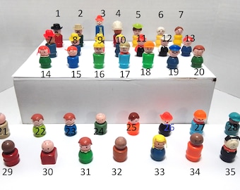Peut inclure: Une collection de 35 figurines en plastique colorées, numérotées de 1 à 35. Les figurines sont toutes de couleurs différentes et ont des expressions faciales différentes. Elles sont disposées en deux rangées sur une surface blanche.