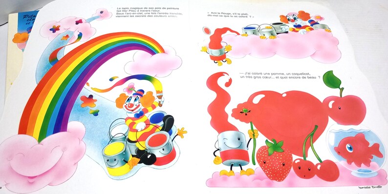 May include: A children's book page illustration featuring a colourful clown painting a rainbow with a brush. The scene includes paint cans, a large red heart, a strawberry, cherries, an apple, and a goldfish in a bowl, all set against clouds.