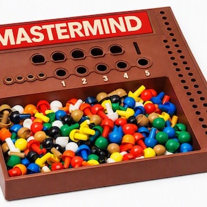 May include: A brown plastic Mastermind board game with a red rectangular label featuring the text MASTERMIND in white. The board includes a storage tray filled with numerous small, colorful plastic pegs in red, blue, yellow, green, white, and tan.