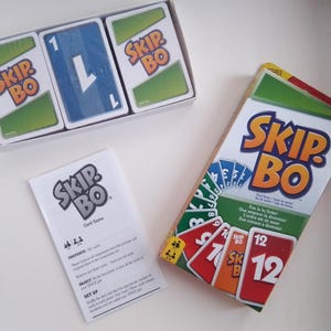 May include: A green and yellow box with the words "Skip-Bo" in large, bold letters. The box contains a card game with instructions and cards numbered 1-12.
