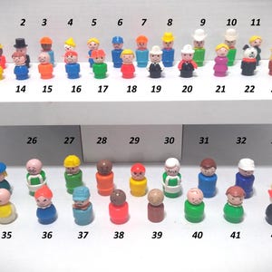 May include: A collection of 42 vintage Fisher-Price Little People figures. The figures are in various colours and outfits, including hats, shirts, and trousers. The figures are arranged on a white shelf.