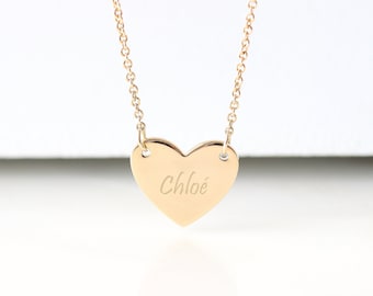 May include: A gold heart-shaped pendant necklace with the name "Chloé" engraved on it.