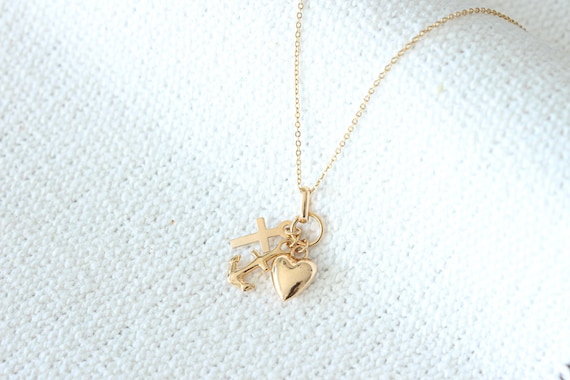 Collier doré à plusieurs breloques : pendentifs ancre, croix et coeur