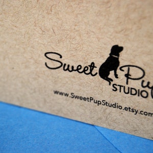 Puede incluir: Primer plano de una tarjeta beige texturizada con el texto negro "Sweet Pup Studio" y una silueta de perro. La direcci&oacute;n del sitio web www.SweetPupStudio.etsy.com tambi&eacute;n est&aacute; impresa en la tarjeta. Una superficie azul es visible en primer plano.