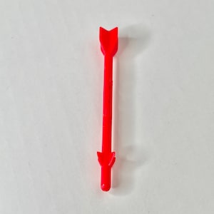 May include: A red plastic arrow with a pointed tip. The arrow is about 5 inches long.