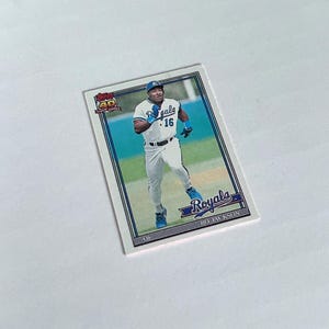 May include: A baseball card featuring Bo Jackson of the Kansas City Royals. The card has a white border with blue accents and the Royals logo. The player is wearing a white uniform with blue trim and the number 16.