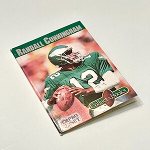 Tarjeta coleccionable del jugador de fútbol americano de la NFL Philadelphia Eagles de Randall Cunningham de 1990 con el juego de cartas coleccionables NFL Pro Set Collect A Book