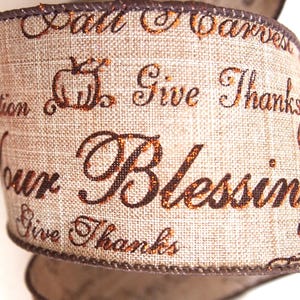 May include: A decorative ribbon with a burlap texture, featuring the words "Fall Harvest," "Give Thanks," and "Your Blessings" in a brown, glittery font. A pumpkin graphic is also visible. The ribbon's edges are trimmed with a darker brown border.