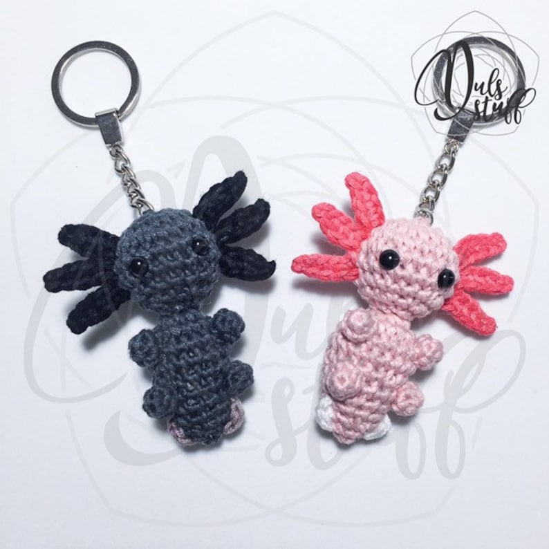 May include: Two crocheted axolotl keychains, one black and one pink, with silver key rings.