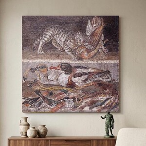 May include: A framed mosaic artwork depicting a cat with prey above ducks and fish. The mosaic features a muted color palette of browns, grays, and whites, creating a classical aesthetic. The artwork is displayed above a wooden cabinet.