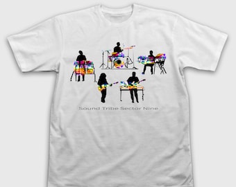 Op de afbeelding: Wit T-shirt met een band silhouet die instrumenten bespeelt met tie-dye patronen. De tekst "Sound Tribe Sector Nine" is eronder gedrukt. De band bestaat uit een drummer, een toetsenist, een gitarist en een percussionist.