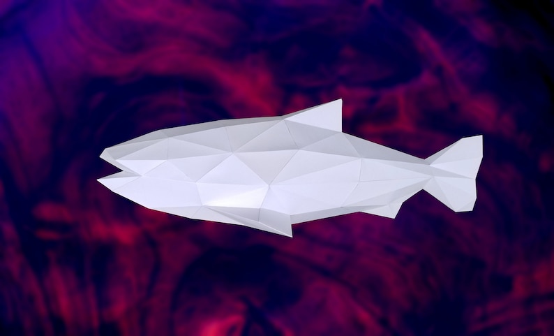 May include: A white origami fish with a geometric design, against a blurred background of red and purple.