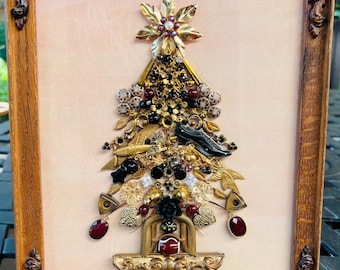 May include: A framed artwork featuring a Christmas tree made of various gold, black, and red jeweled embellishments. The tree is decorated with small, ornate gold ornaments, black and red beads, and a star-shaped topper.