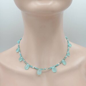 Puede incluir: Un delicado collar turquesa y plateado con cuentas en forma de l&aacute;grima.