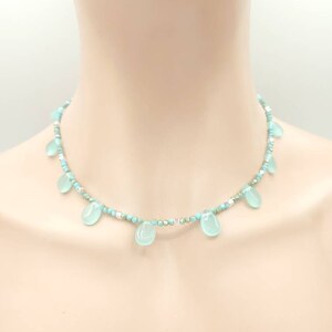Puede incluir: Un delicado collar turquesa y plateado con cuentas de turquesa en forma de l&aacute;grima.