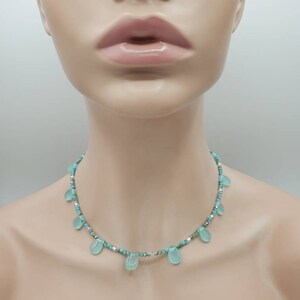 Puede incluir: Un collar turquesa y plateado con cuentas de turquesa en forma de l&aacute;grima.