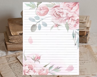 May include: A printable stationery sheet with a floral design featuring pink roses and green leaves. The background is white with light pink and gray watercolor accents. The sheet has lined paper for writing.