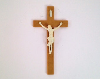 May include: A wooden crucifix with a white plastic figure of Jesus Christ.