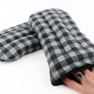 K&ouml;nnte beinhalten: Ein Paar Ofenhandschuhe in Schwarz-Wei&szlig;-Karos mit schwarzem Fleece-Futter. Die Handschuhe sind gesteppt und haben eine dicke Isolierschicht zum Schutz vor Hitze.