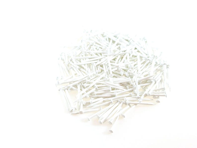 Pode incluir: Um grande monte de tachinhas de metal branco. As tachinhas s&atilde;o pequenas e t&ecirc;m uma ponta afiada.