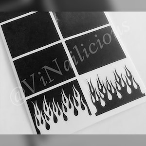 May include: Black and white nail art stencils featuring a flame design. The stencils are on a white background and are ready to be used for nail art.