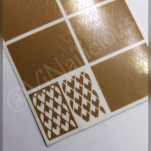 Può includere: Un foglio di stencil per nail art dorati con vari motivi geometrici. Gli stencil sono progettati per essere utilizzati con lo smalto per unghie per creare disegni intricati.