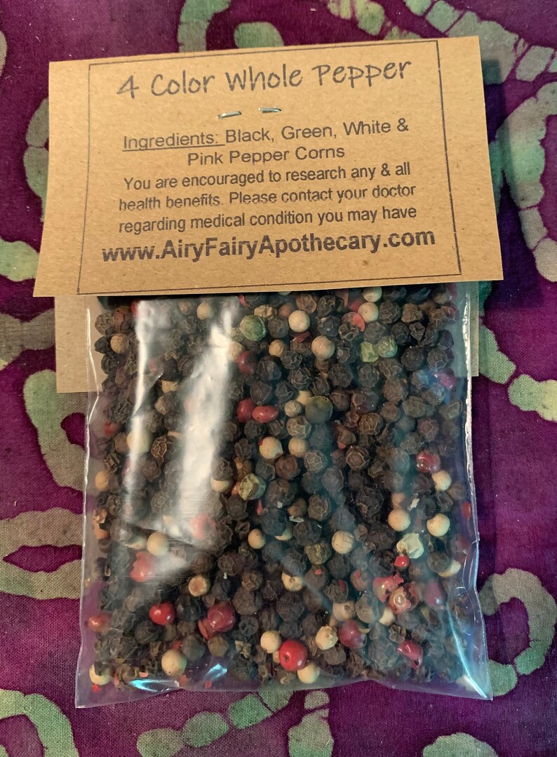 May include: A close-up of a bag of four-color whole peppercorns. The peppercorns are black, green, white, and pink. The bag is labeled "4 Color Whole Pepper" and includes the ingredients: "Black, Green, White & Pink Pepper Corns". The label also includes the website address: "www.AiryFairyApothecary.com".