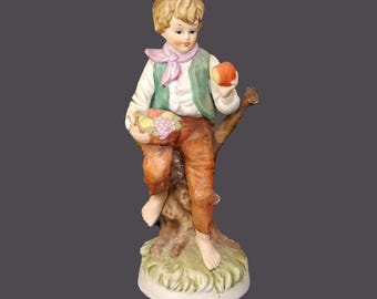 Giftcraft porcelain bisque figurine. Young boy holding fruit. Made in Japanese Taiwan. Flaws (see below).