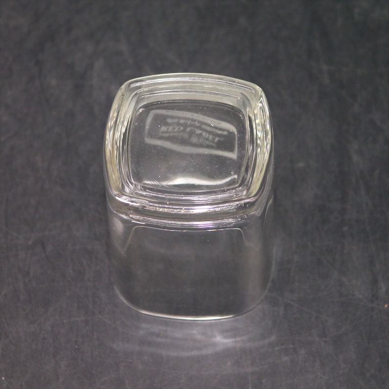 Peut inclure: Un verre &agrave; boire en verre transparent de forme carr&eacute;e avec un fond l&eacute;g&egrave;rement arrondi. Le verre a un bord sur&eacute;lev&eacute; et une surface lisse. Le fond du verre porte l'inscription "Keez-Whizz".