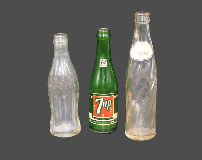 Three mid-century glass soda pop bottles Pepsi, 7Up, Coke. No caps. Great home bar decor.