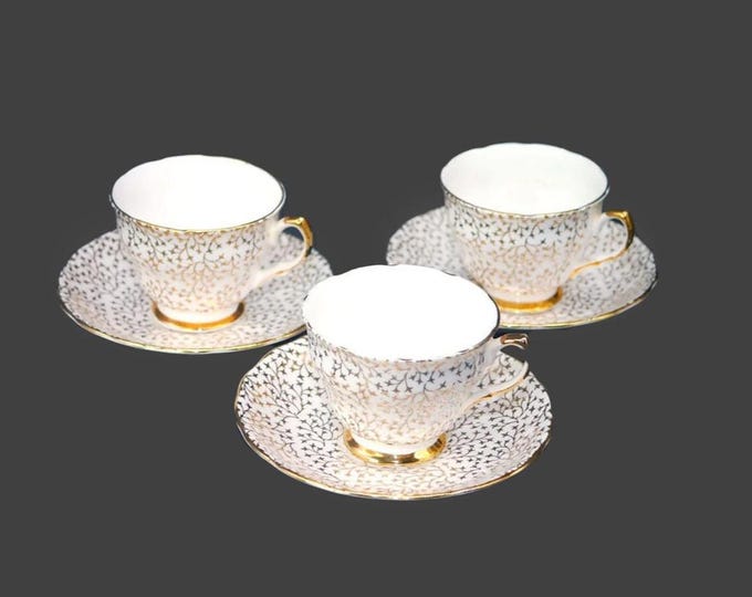 Three Crown Regent gold floral chintz cup and saucer sets made in England. Flaw (see below).