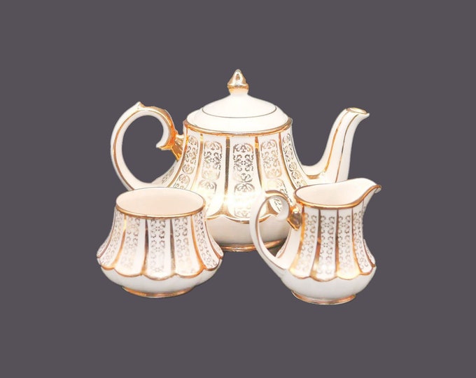 Sadler 3181 teapot, creamer and open sugar bowl set made in England. Gold scrolls on cream.