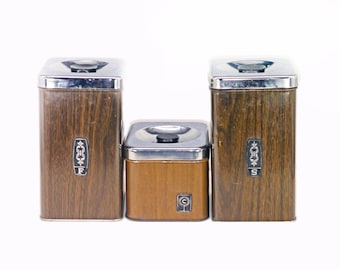 Three retro Ekco faux woodgrain canisters sugar, flour, and coffee. Chrome lids. Made in Canada.