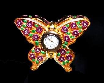 Movt pill box quartz clock in shape of butterfly. Totally blinged out with multicolor rhinestones. Made in Japan.