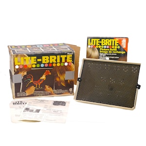 May include: A Lite-Brite toy set with a black and white box, a black and beige light-up board, and a box of picture refills. The box has a picture of two children creating a rooster design on the board. The box says "Lite-Brite" and "Picture Refill Image de recharge".