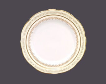 Foley bone china dinner plate made in England. Golden circles, five-petaled flowers on yellow with green bands. Flaw (see below).
