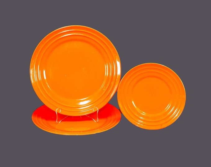 Three Rachael Ray Double Ridge Tangerine stoneware plates. Two large dinner, one salad plate.