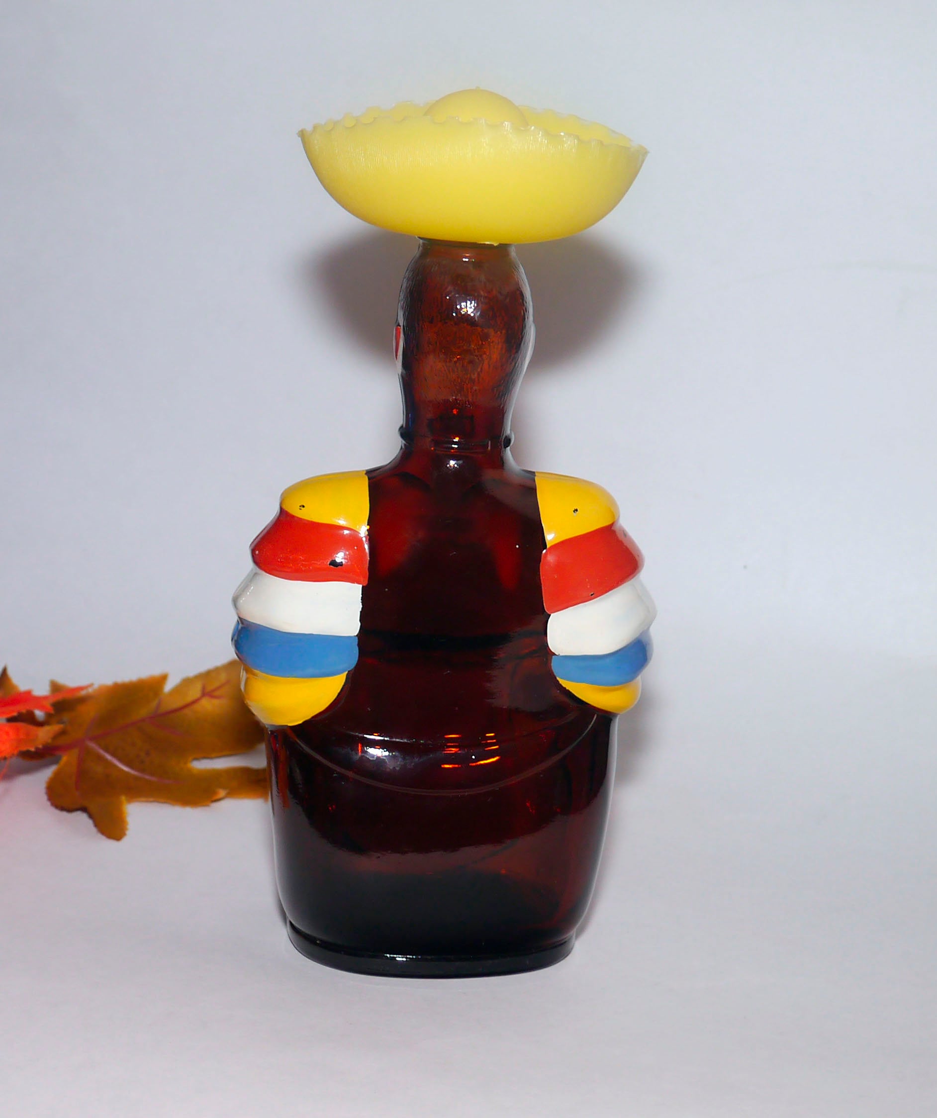 Old Oak Rum empty Limbo Drummer bottle. Original yellow plastic Sombrero lid. Made by Angostura