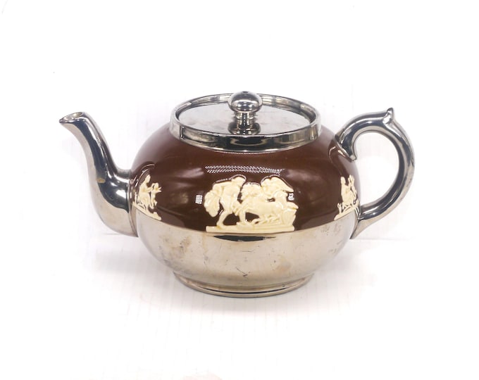 Gibsons 4699 four-cup teapot made in England. High-relief Greco-Roman scenes on brown, platinum accents. Flaws (see below).