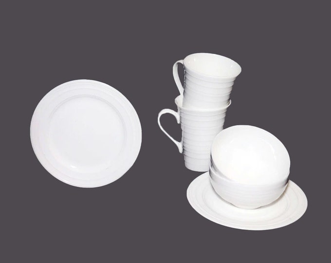 Mikasa Swirl White all-white tableware of two mugs, two side plates, two cereal bowls.