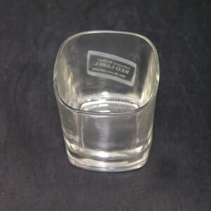 Peut inclure: Un verre &agrave; whisky en verre transparent avec une base carr&eacute;e et des bords arrondis. Le verre porte l'inscription "Johnnie Walker Red Label" grav&eacute;e au fond.
