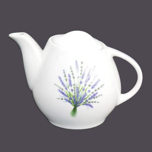 May include: White ceramic teapot with a lavender floral design. The teapot has a rounded body and a spout on one side.